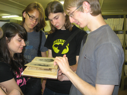 Студенты держат в руках фотоальбом начала XX века